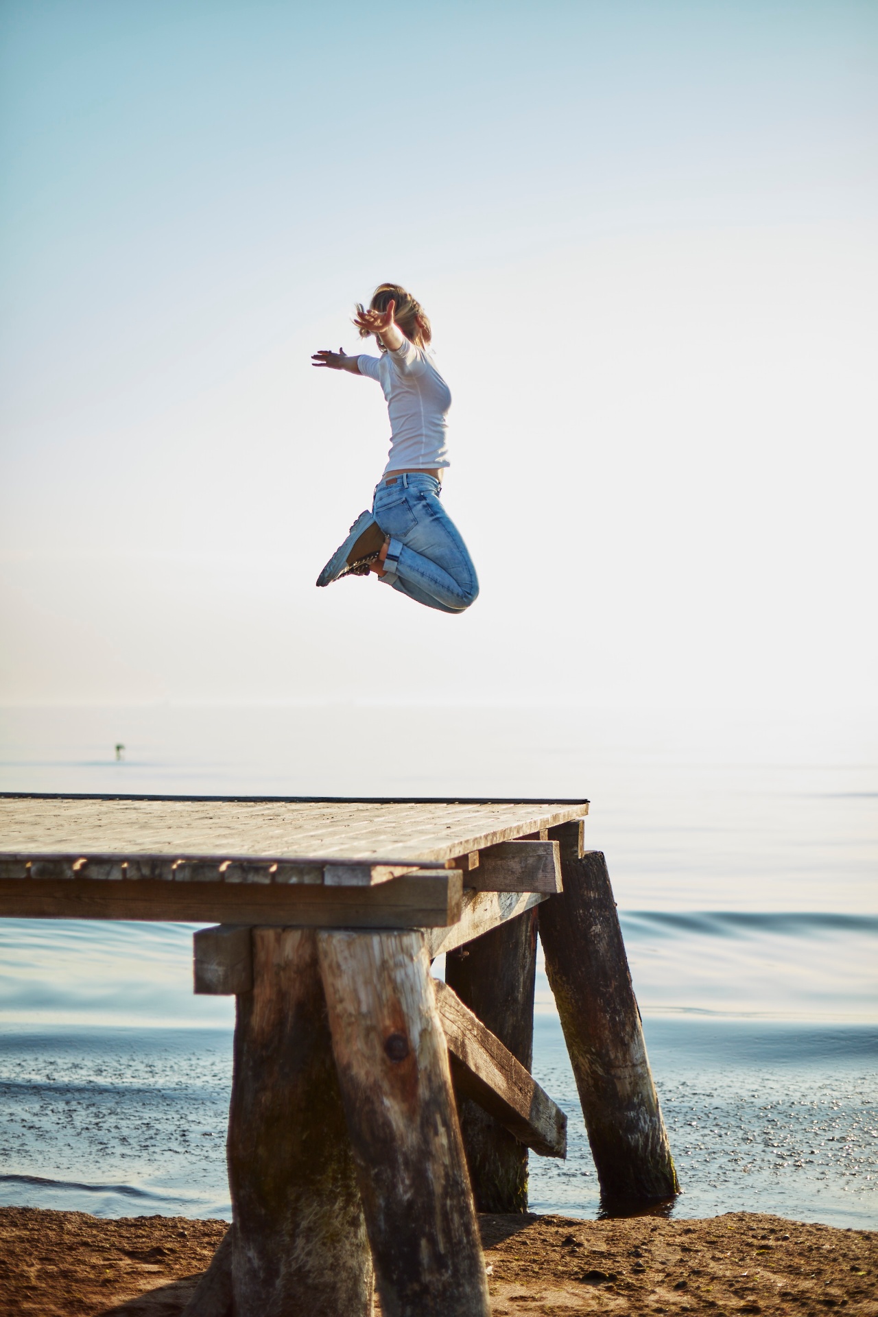 Leaping from a pier at sunrise